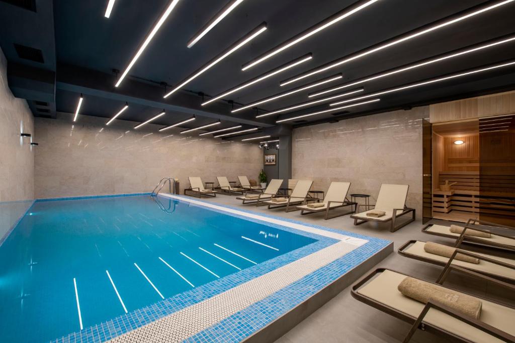 una piscina in un edificio con sedie intorno di Bristol Hotel and Spa Bakuriani a Bakuriani