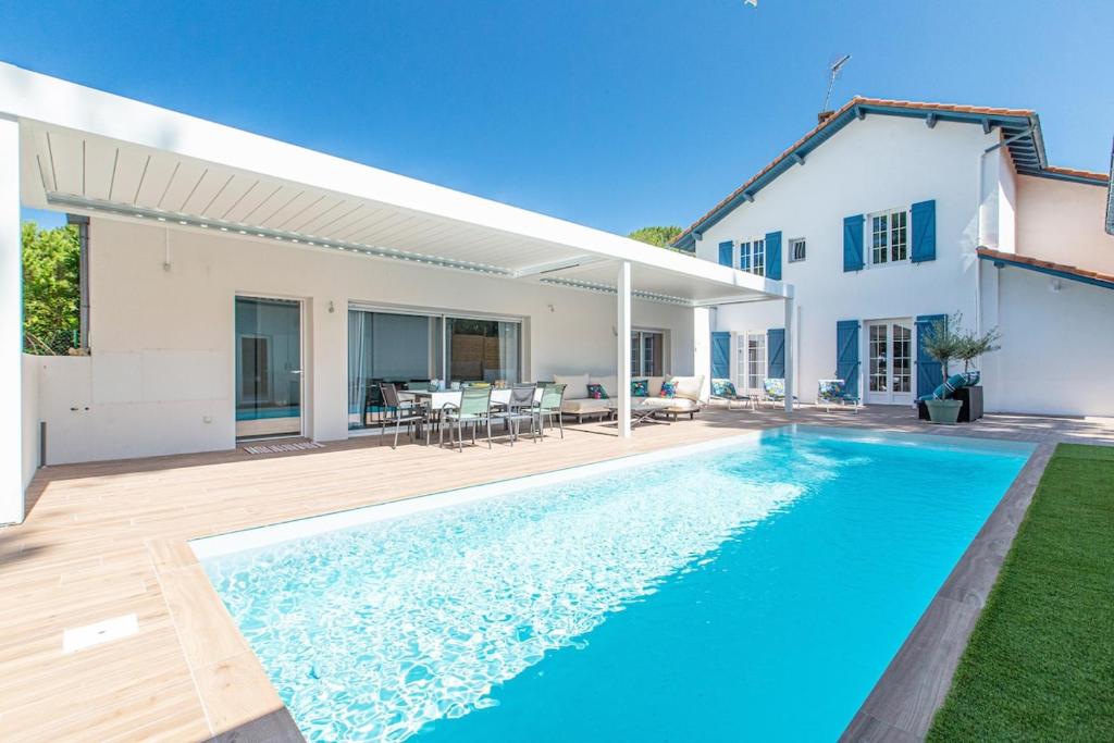 a villa with a swimming pool and a house at Dépendance Villa Souleillous in Capbreton