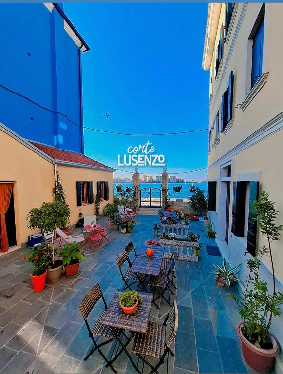 an outdoor patio with tables and chairs and the ocean at Corte Lusenzo in Chioggia
