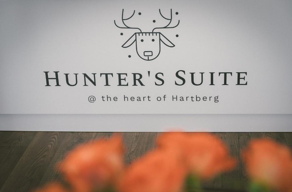 a sign for the head of a deer with orange flowers at "Hunter's Suite"- at the heart of Hartberg I Parking in Hartberg