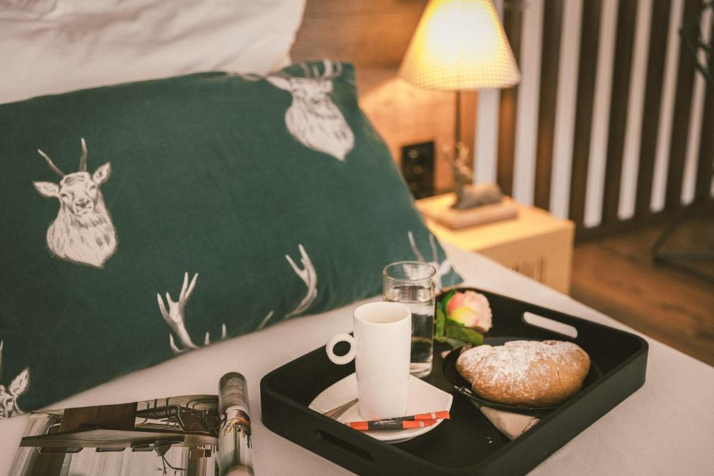 a tray of food and a drink on a bed at "Hunter's Suite"- at the heart of Hartberg I Parking in Hartberg