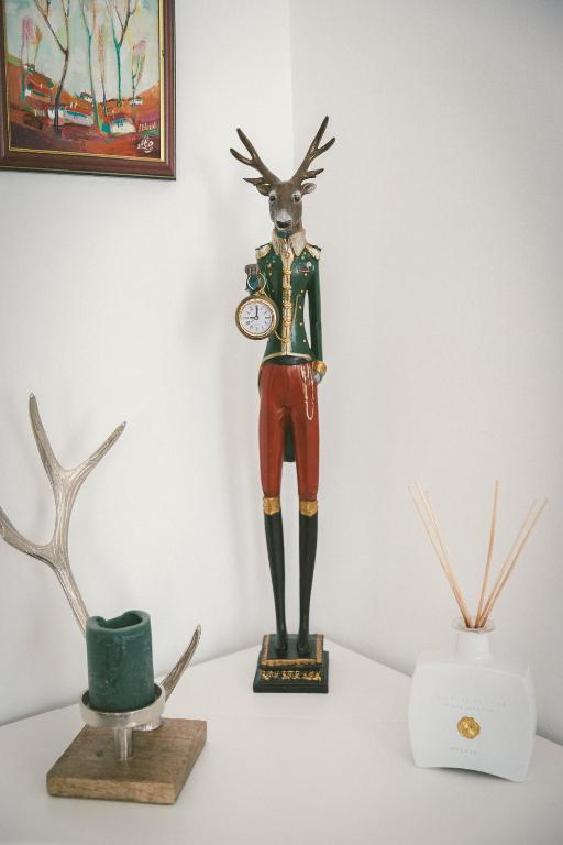 a statue of a deer with a clock on a table at "Hunter's Suite"- at the heart of Hartberg I Parking in Hartberg