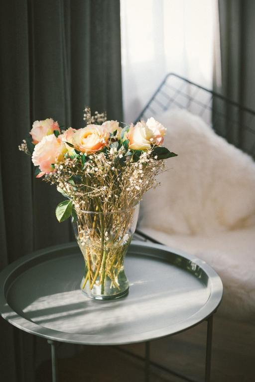 a vase filled with pink roses on a table at "Hunter's Suite"- at the heart of Hartberg I Parking in Hartberg