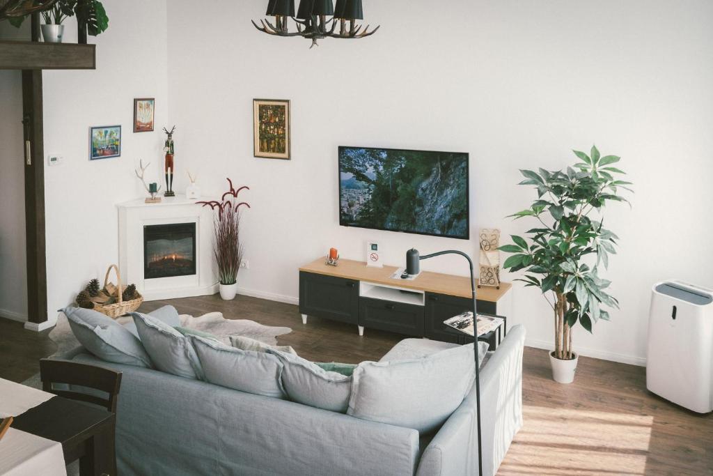 a living room with a couch and a tv on the wall at "Hunter's Suite"- at the heart of Hartberg I Parking in Hartberg