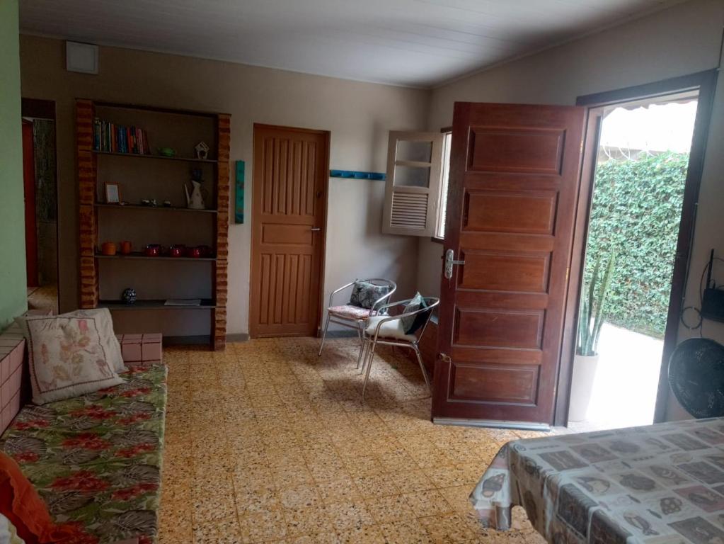 a bedroom with a bed and a door and a chair at Casa Centro pertinho da praia in Piúma
