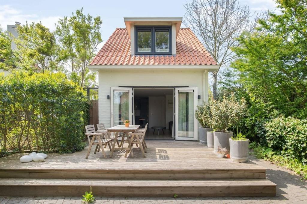 een terras met een tafel en stoelen voor een huis bij Hello Zeeland - Vakantiehuis Duinenburg 22A in Domburg