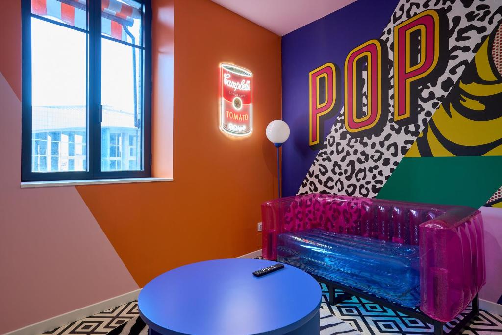 une pièce colorée avec un banc et une enseigne pop dans l'établissement Appart InstaPOP'ART by La Villa Orange, à Carcassonne