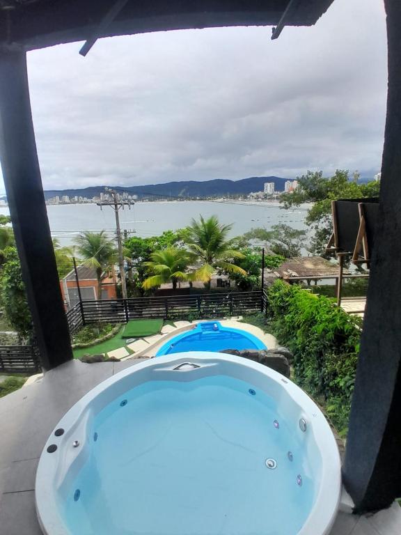 a jacuzzi tub with a view of the water at Casamar paraíso na praia com a vista do mar dos sonhos piscina e spa in Guarujá