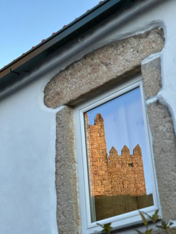 a reflection of a castle in a window at Casa do Castelo in Trancoso