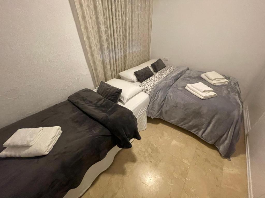 sypialnia z 2 łóżkami pojedynczymi i białą kanapą w obiekcie Apartamento Las Brisas w mieście Mijas