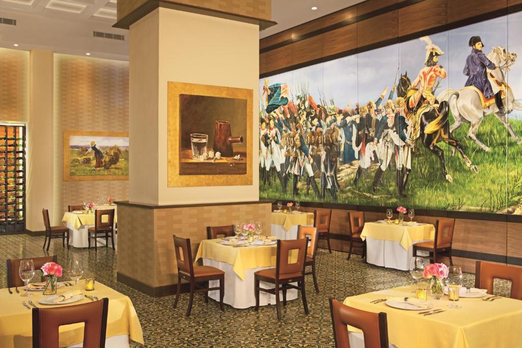 a dining room with tables and a large painting on the wall at Secrets Vallarta Bay Resort & SPA - Adults Only in Puerto Vallarta
