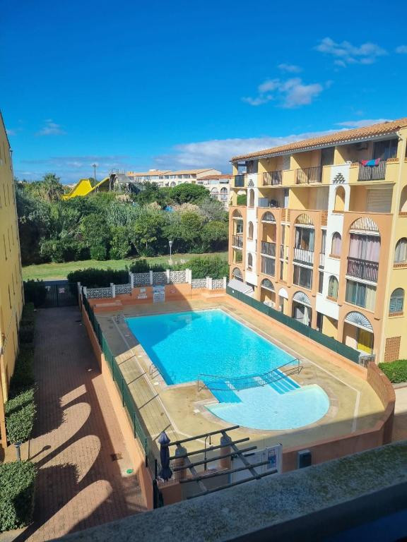 une grande piscine à côté d'un immeuble dans l'établissement Appart lumineux Piscine Parking, au Cap d'Agde