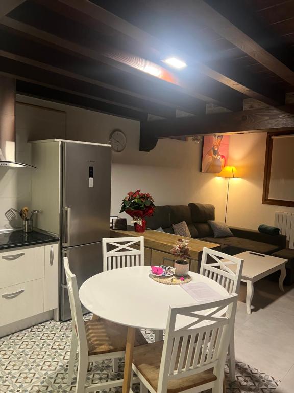 a kitchen and living room with a white table and chairs at Apartamento dúplex en Sangüesa de 3 dormitorios y 2 baños in Sangüesa