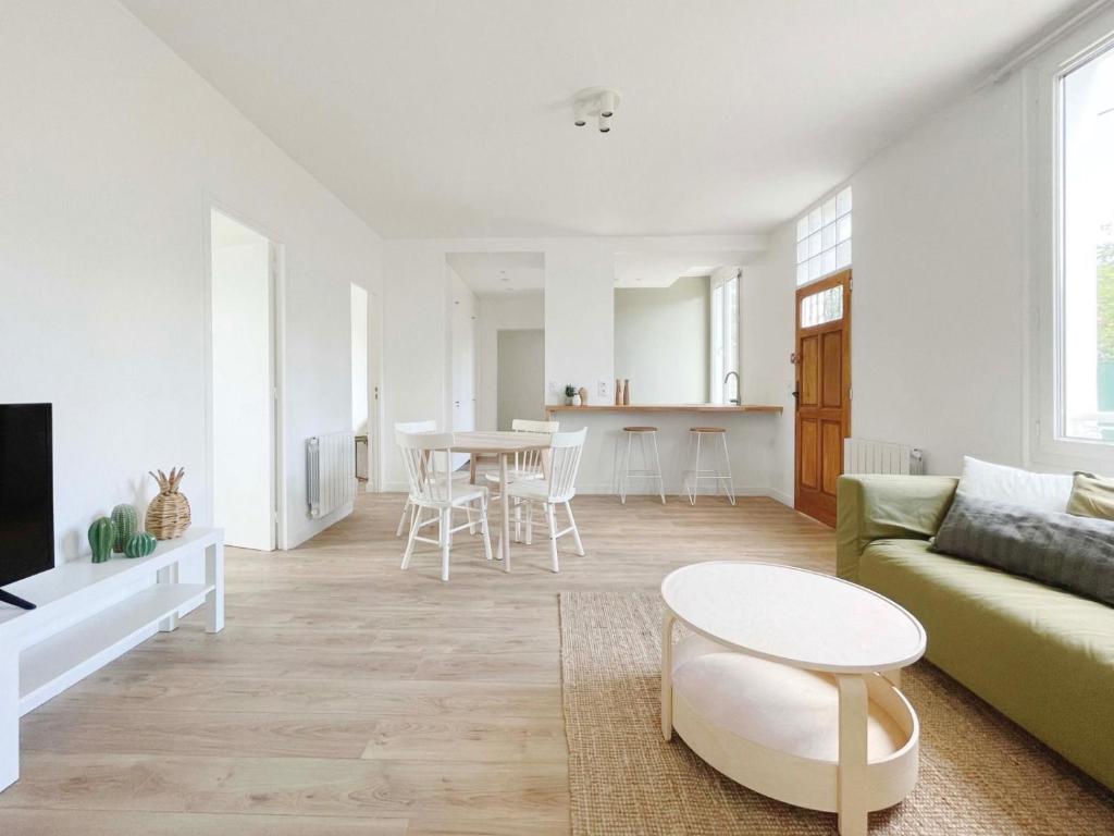 a living room with a green couch and a table at Ma Belle Conciergerie - Le Cocon Mélunais in Melun