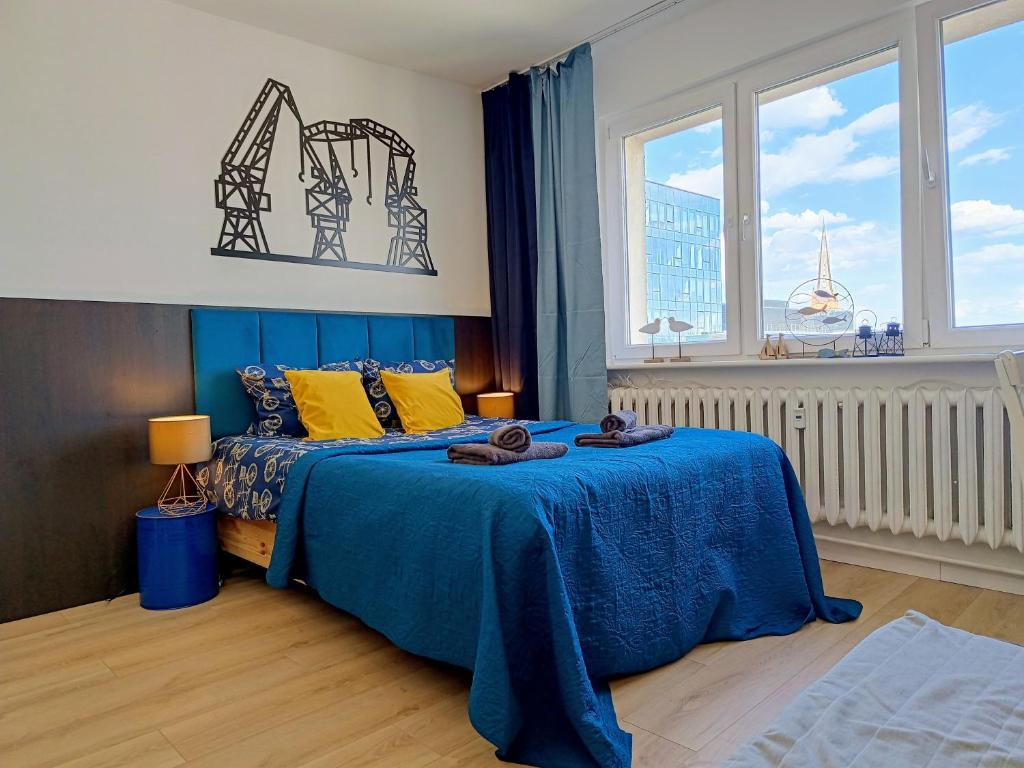a bedroom with a blue bed and a window at Good Night in Szczecin in Szczecin