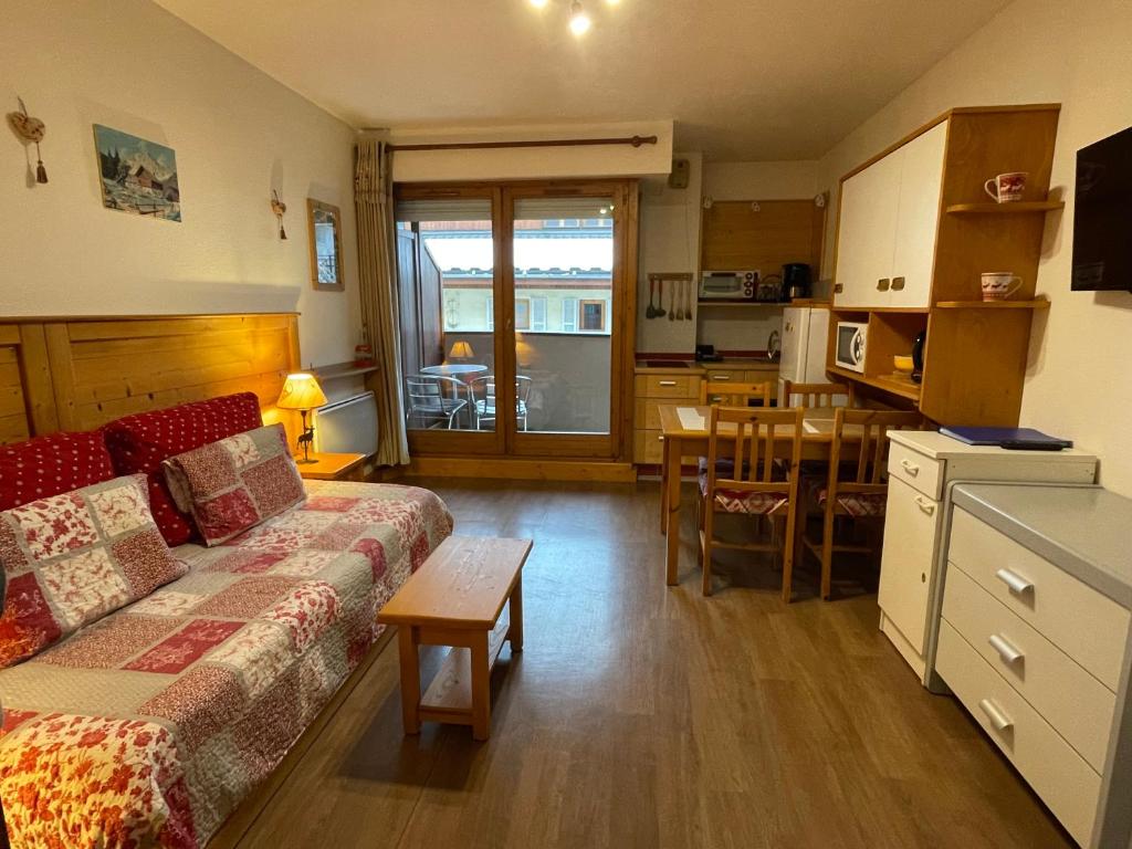 a living room with a couch and a table and a kitchen at Studio Acacia Brides Les Bains in Brides-les-Bains