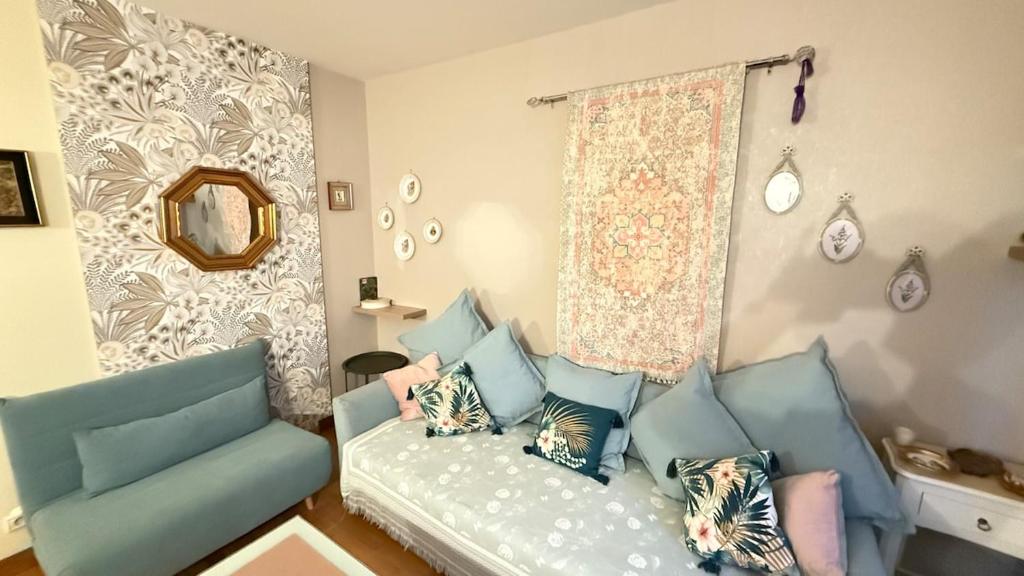 un salon avec un canapé et un miroir dans l'établissement Les balcons de Victor Hugo, à Paris