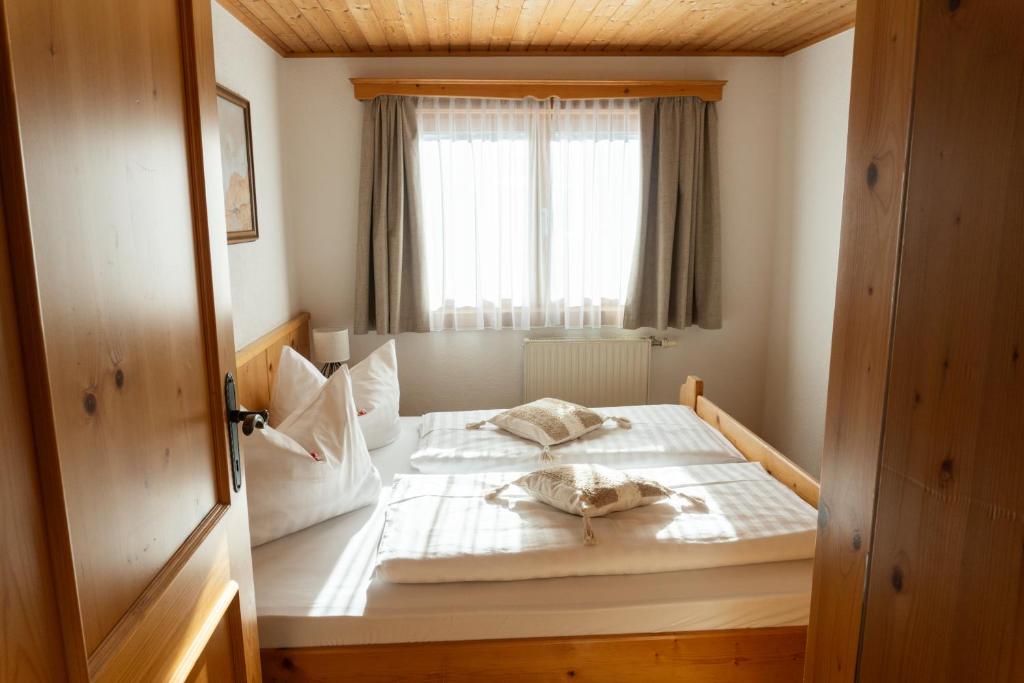 una cama en una habitación con ventana en Gipfelglück Appartements - Ski in & Ski out, en Bad Kleinkirchheim