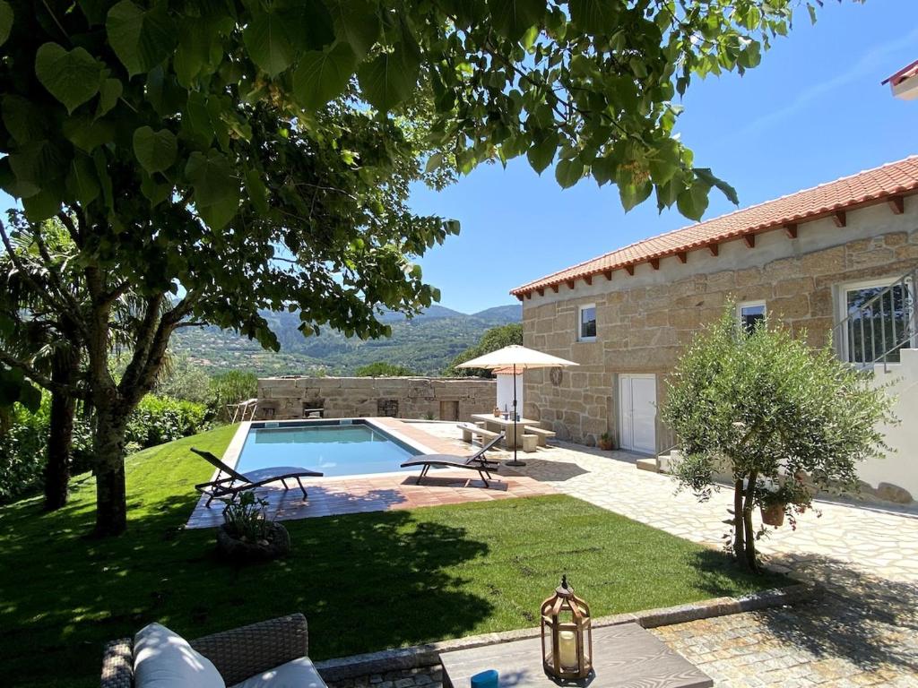 un giardino con piscina e una casa di Quinta do Rio Douro - Turismo Rural Paços de Gaiolo, Porto a Paços de Gaiolo