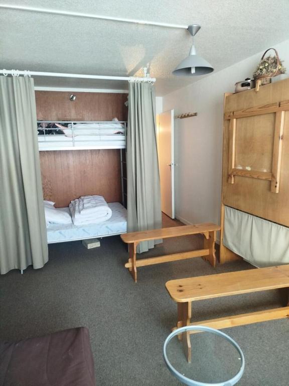 Cette petite chambre comprend des lits superposés et un banc. dans l'établissement Résidence Le Tourmalet - maeva Home - Studio 5 personnes - Confort MAE-8581, à La Mongie