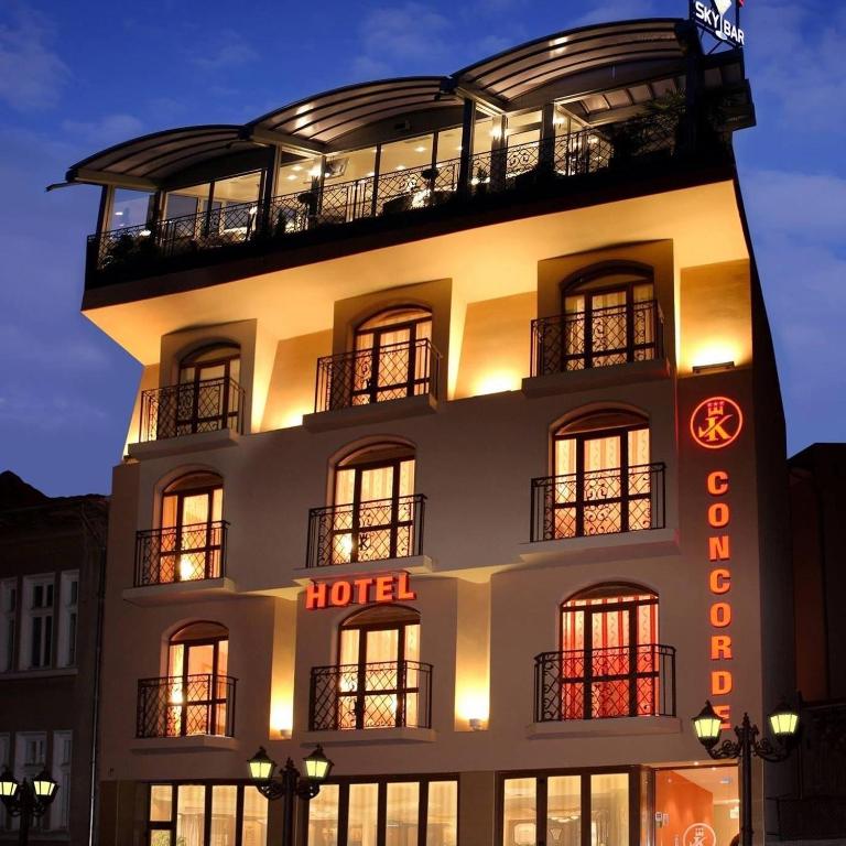 a hotel building with a clock on the side of it at Hotel Concorde in Veliko Tŭrnovo