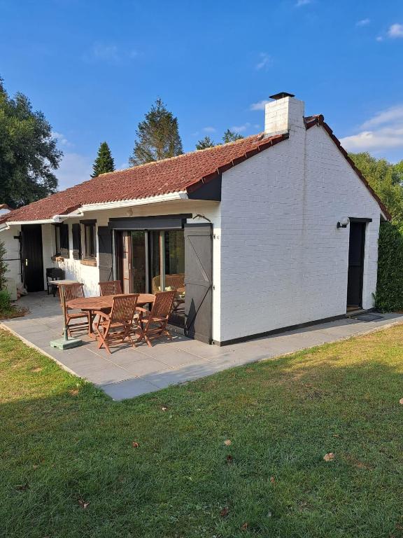 a house with a table and chairs on a patio at Vakantiehuis Bernadette in Heuvelland