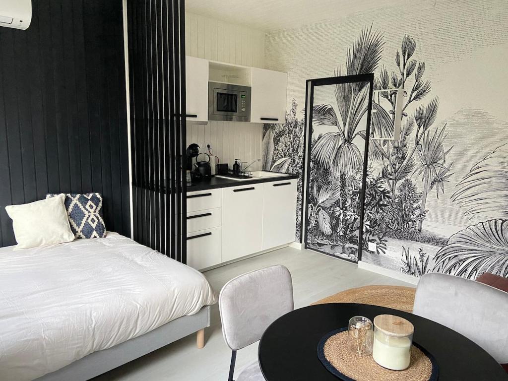 une chambre avec un lit et une table et une cuisine dans l'établissement Nouveau Studio Oasis, à Chasseneuil-du-Poitou
