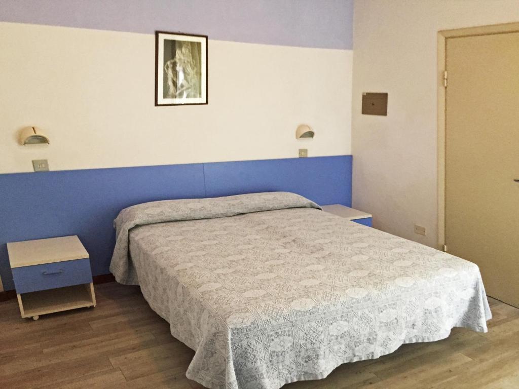 海上米蘭的住宿－海濱長廊酒店，一间卧室设有一张床和蓝色的墙壁