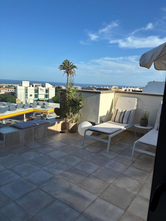 a balcony with two chairs and a view of the city at Atico acogedor con vistas in Telde