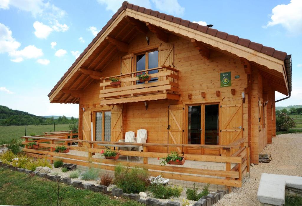 une cabane en rondins avec un porche et une fenêtre dans l'établissement DROUVENANT chalet 10 personnes, à Charcier