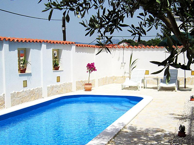 una piscina di fronte a un edificio con una casa di Fresh Apartments Dar Orlic a Trogir
