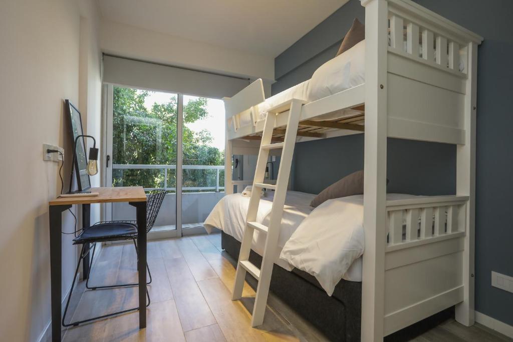 ein Schlafzimmer mit einem Etagenbett, einem Schreibtisch und einem Fenster in der Unterkunft Luxurious and modern Apartment With Cochera Palermo Hollywood in Buenos Aires