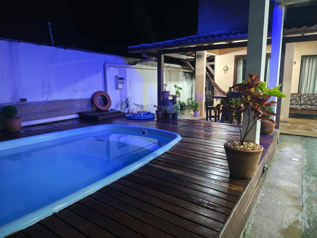a large bath tub sitting on a wooden deck at Aconchegante casa de Temporada em Búzios. in Armacao dos Buzios