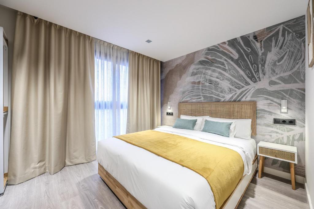 a bedroom with a large bed and a wall mural at ATyCO Madrid in Madrid
