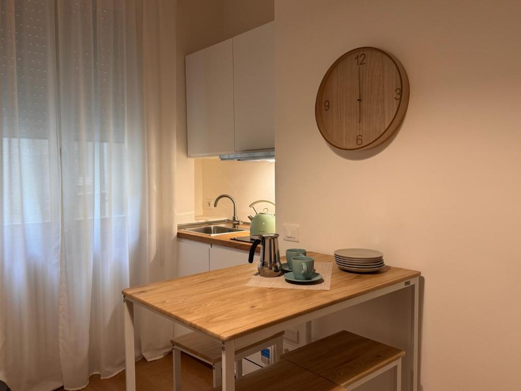 une cuisine avec une table et une horloge au mur dans l'établissement Alle 4 Stagioni - Appartamento 1, à Rimini