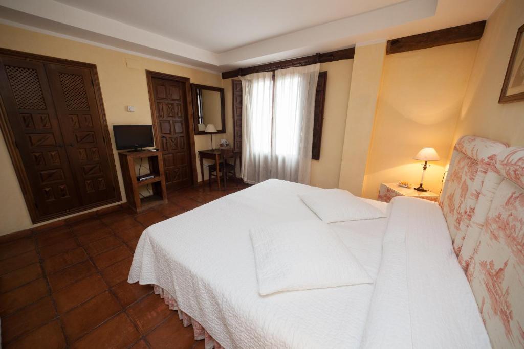 A bed or beds in a room at Hotel Restaurante Doña Anita
