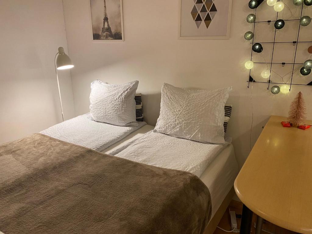 a small bedroom with two beds and a table at Cozy and peaceful Punavuori in Helsinki