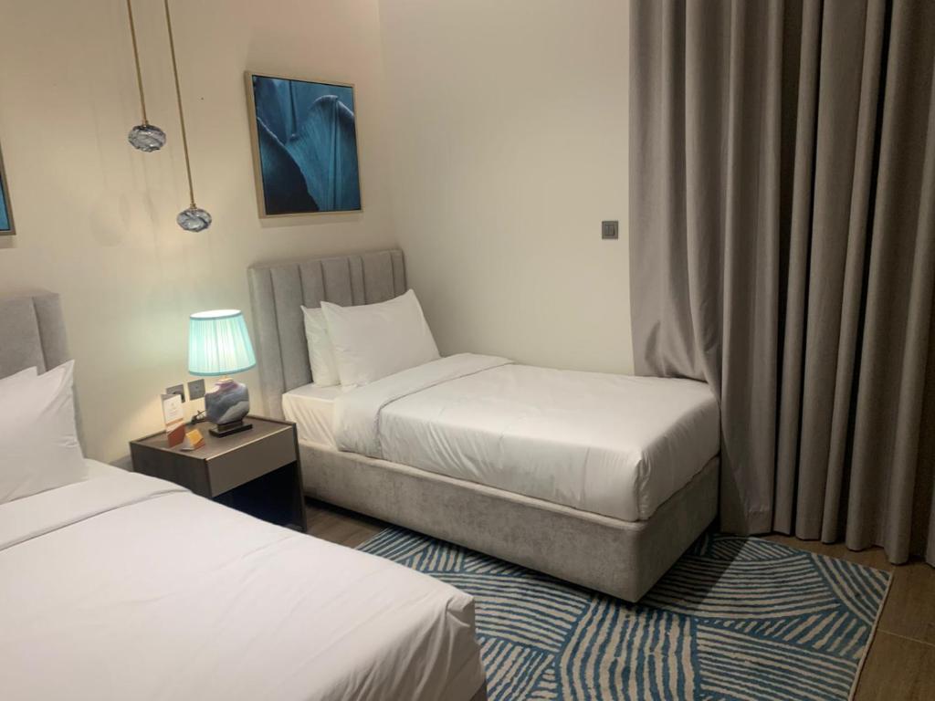 a hotel room with two beds and a table with a lamp at فندق ليورا Liora Hotel in Riyadh