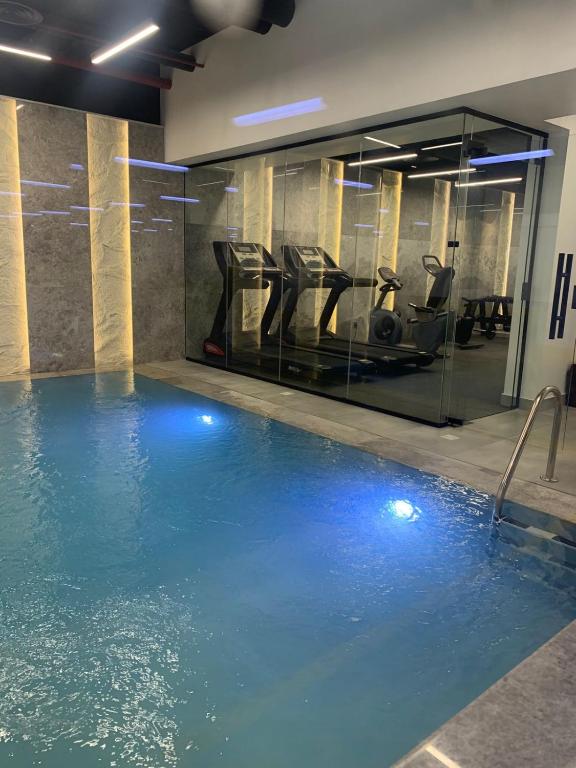 a gym with a swimming pool with exercise equipment at فندق ليورا Liora Hotel in Riyadh