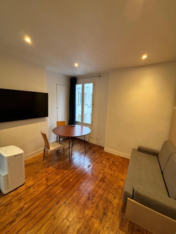 un salon avec une table et un canapé dans l'établissement Paris Hittorf, à Paris