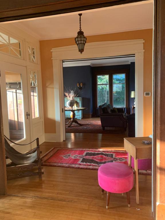 a living room with a table and a pink stool at Lion's Head B&B in Niagara Falls