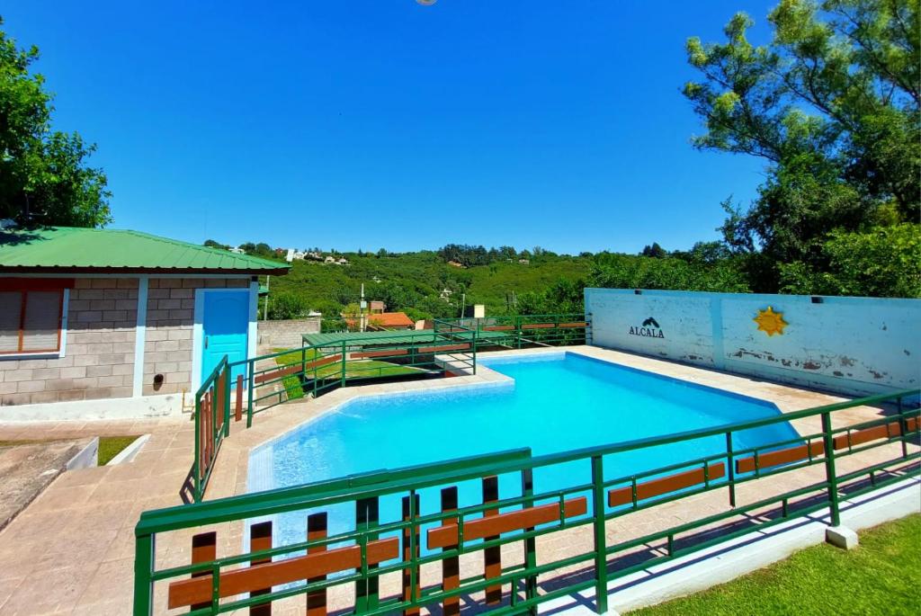 a large swimming pool with a fence around it at Hosteria Alcala in La Falda
