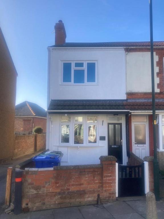 a white house with a brick fence in front of it at White Sands, NEWLY renovated central 2 bed house near Cleethorpes beach and all amenities in Cleethorpes