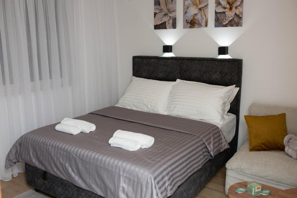 Apartman studio GRUBAC في تريبينيي: غرفة نوم بها سرير عليه منشفتان