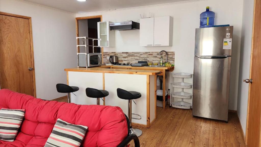un salon avec un canapé rouge et une cuisine dans l'établissement Arriendo de Verano 4 dormitorios, à Valparaíso