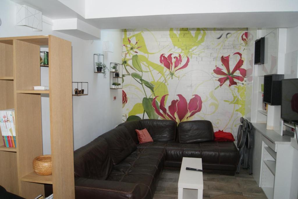 un salon avec un canapé et une fresque florale dans l'établissement Maison de vacances aux portes de Paris, aux Lilas