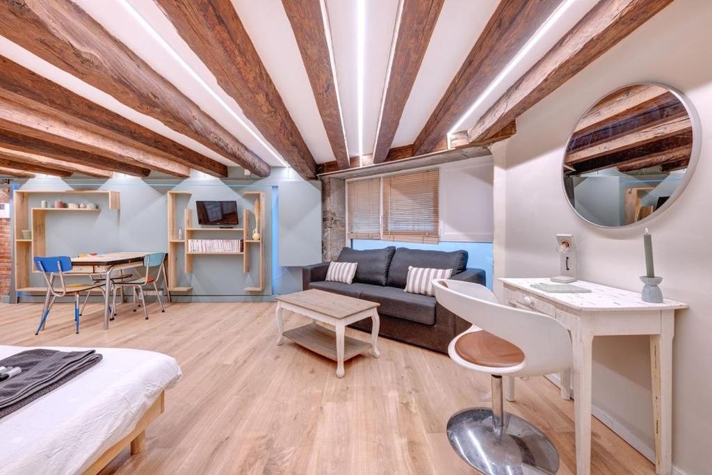 Cette chambre comprend un lit, un canapé et une table. dans l'établissement La Cabane Bellecour, à Lyon