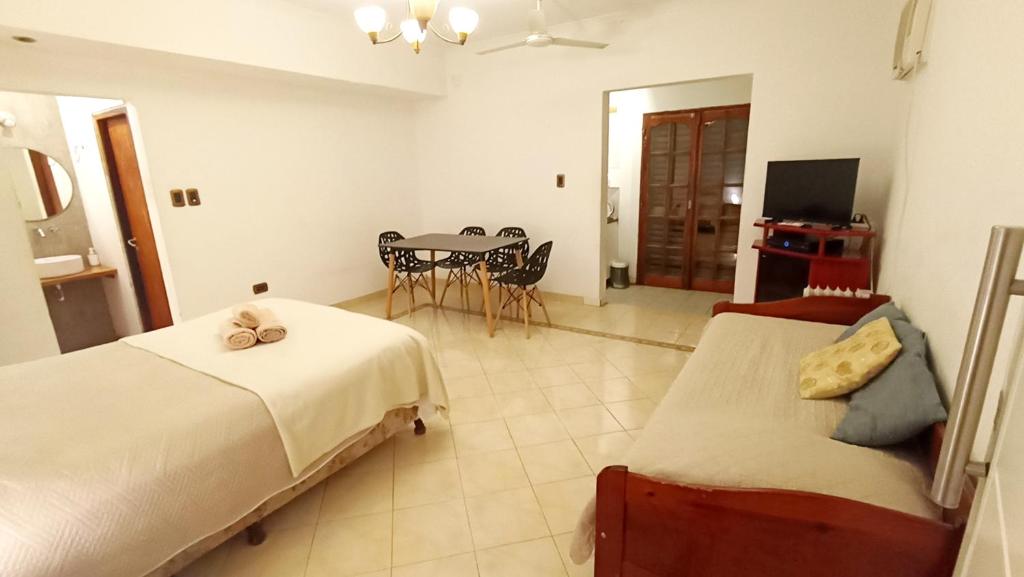 a bedroom with two beds and a table with a television at Amplios Departamentos en Corrientes in Corrientes