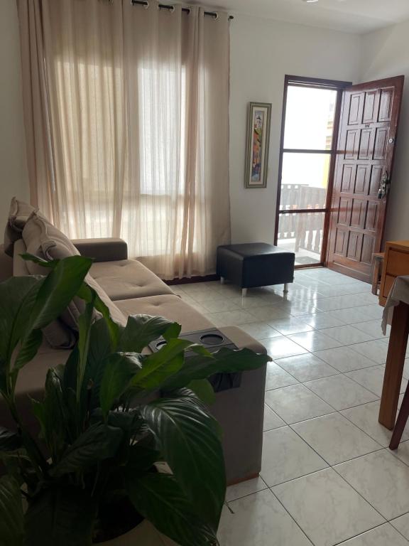 a living room with a couch and plants in it at Apartamento em Cabo Frio in Cabo Frio