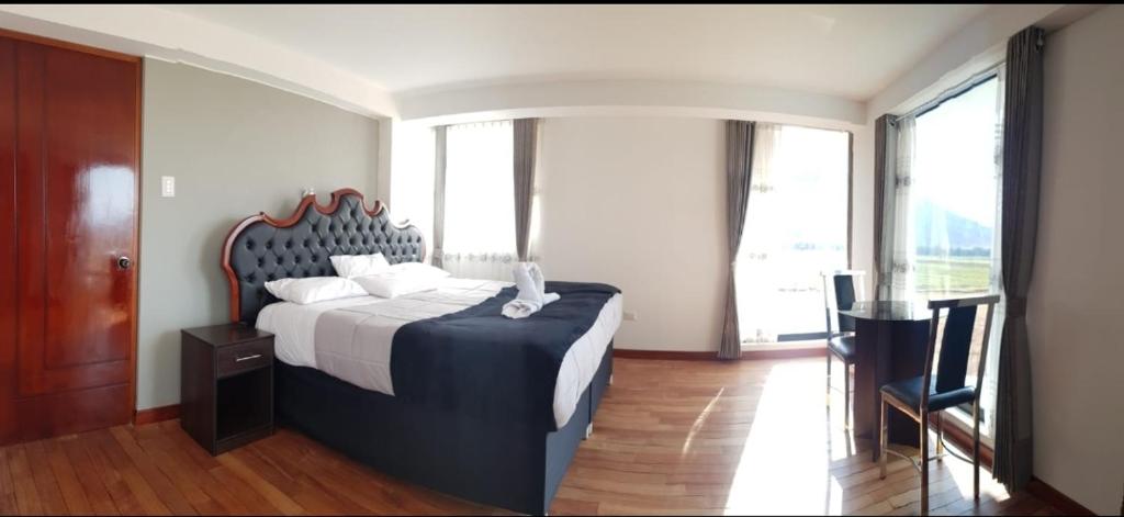 une chambre avec un grand lit avec une grande fenêtre dans l'établissement Casa isaaleya, à Cusco